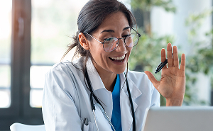 Female doctor smiling during an online consultation, representing personalised hormone care through telehealth.
