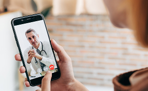 Man on smartphone video call with a Fem Excel healthcare provider, symbolising convenient access to virtual hormone therapy.