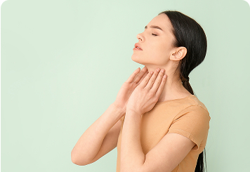 Woman touching her neck near the thyroid area, eyes closed in calm reflection, representing thyroid awareness and the connection between thyroid function and hormonal balance.