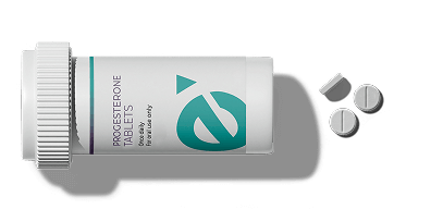 Two prescription bottles labeled Progesterone Tablets and Thyroid Capsules with tablets scattered beside them on a light background.