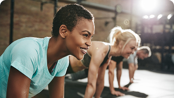 smiling during a workout, representing PCOS symptoms such as irregular periods, weight gain, fatigue, and fertility concerns.