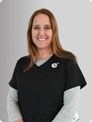 Sarah Garrand, FNP-BC, Nurse Practitioner at Fem Excel, smiling in black scrub top with grey undershirt.