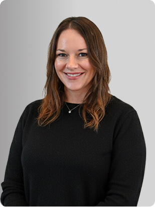 Lindsay Marcy, APRN, FNP-C, ENP-C, Nurse Practitioner at Fem Excel, smiling in black medical uniform.