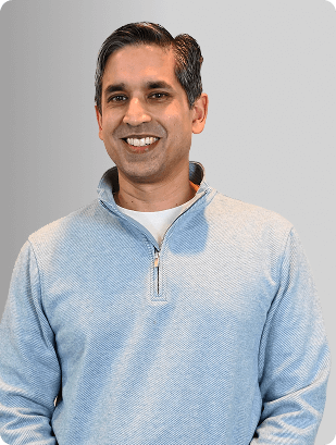 Andrew Abraham, MD, Physician at Fem Excel, smiling in gray sweater.