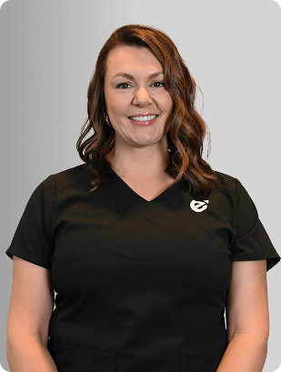 Kelly Donoho, MSN, FNP-BC, Nurse Practitioner at Fem Excel, smiling in black medical uniform.