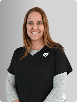 Sarah Garrand, FNP-BC, Nurse Practitioner at Fem Excel, smiling in black scrub top with grey undershirt.