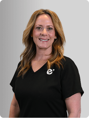 Paige McDonald, MSN, APRN, FNP-BC, Nurse Practitioner at Fem Excel, smiling in black polo with Fem Excel logo.
