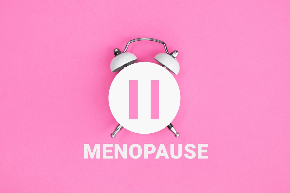 White-vintage-alarm-clock-with-an-inscription-MENOPAUSE-on-pink-background