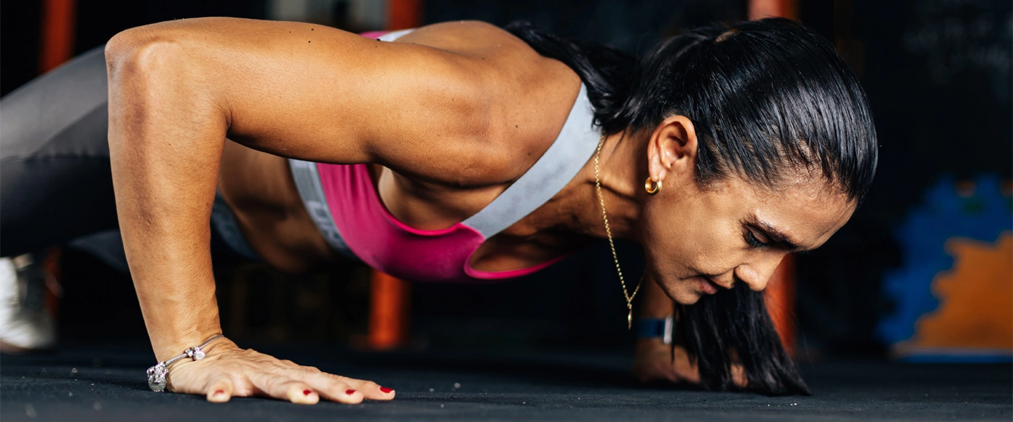 WomenMuscleMass Muscle mass and hormones hero. Woman doing press ups.