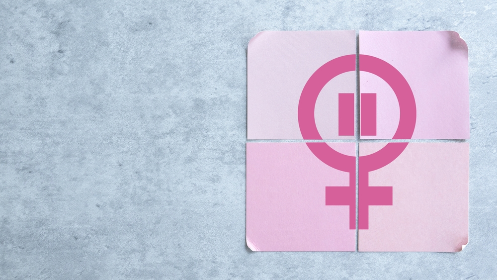 Four Pink Cards Arranged to Form a Menopause Symbol Over a Gray Background