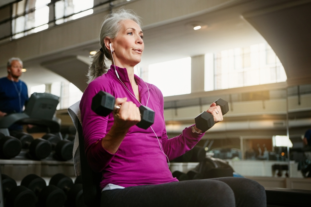 Portrait of a senior woman working out with weights at the gym