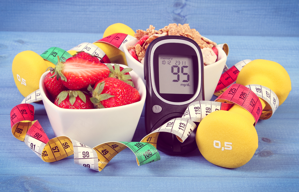 Glucose meter with sugar level healthy food dumbbells for fitness and tape measure healthy lifestyle for diabetes concept