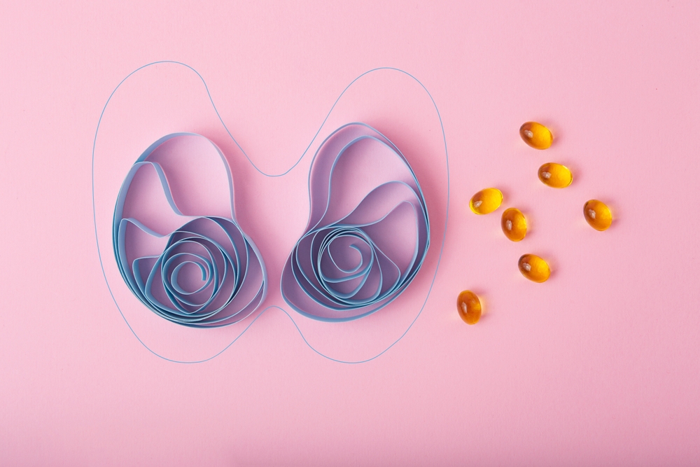 Top view of paper thyroid gland with gelatin capsules and tablets World thyroid day concept