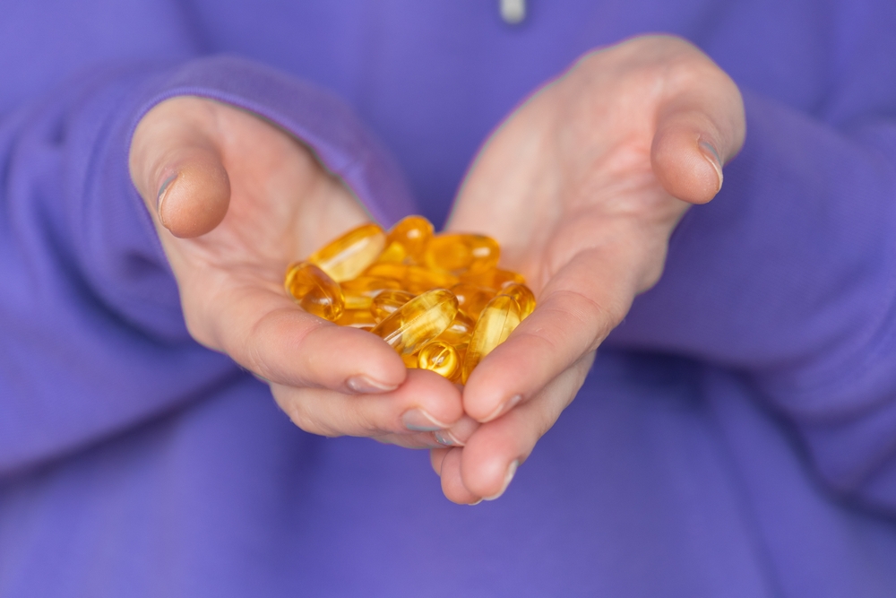 close up of fish oil capsules in a womans hands