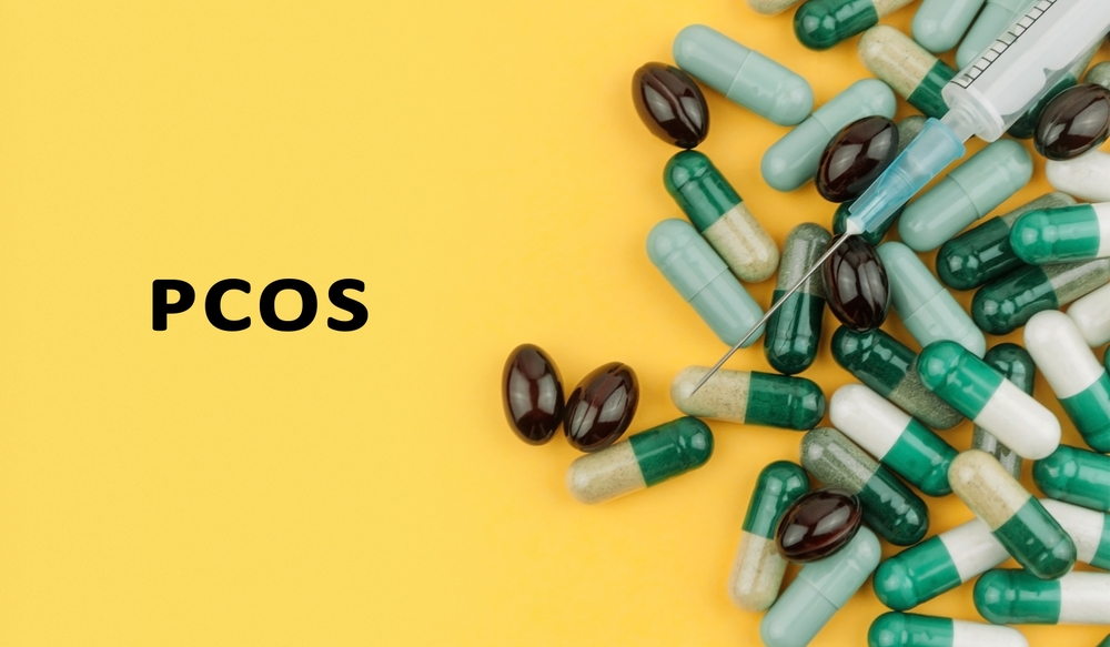 Bunch of pills with a syringe on top of them next to the word PCOS in black text over yellow background