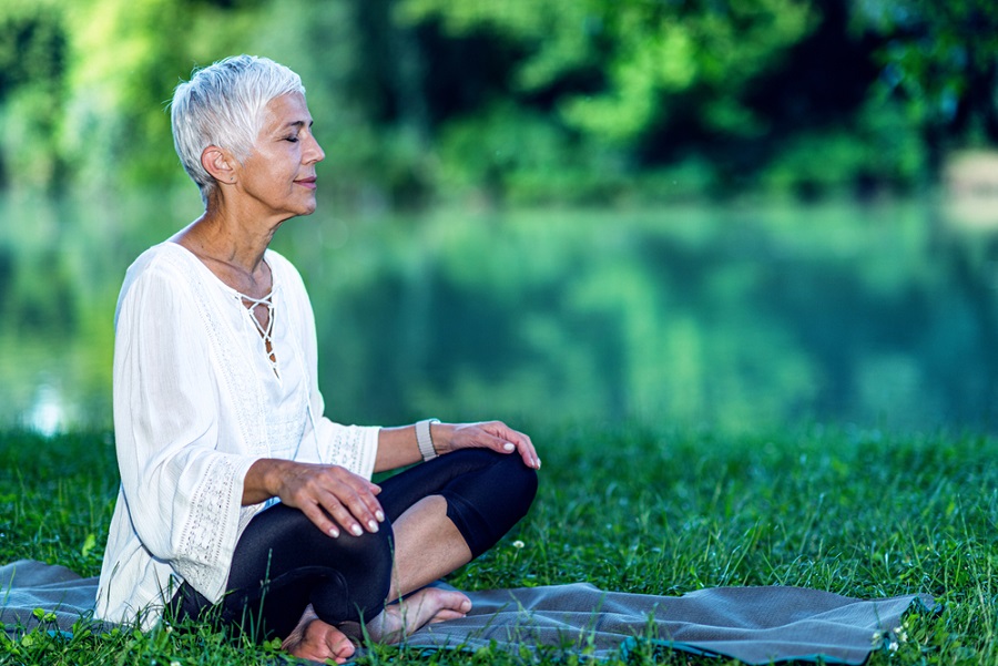 lifestyle-changes-for-perimenopause-senior-woman-doing-mindfulness-meditation-outdoors-in-a-park